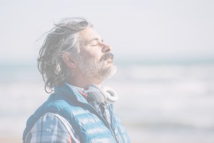 Photo of a man facing the sea, closing his eyes