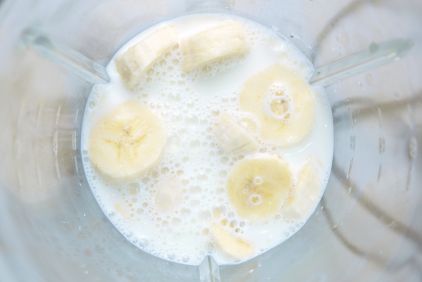 Photo de morceaux de banane au fond d'un blender avec du lait végétal