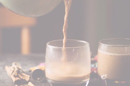 Casserole pouring chai latte into a glass